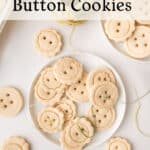 A plate and table filled with round, button-shaped cookies, some with four holes, arranged neatly. Spools of twine and a baking tray are also visible, creating a charming, homemade look.