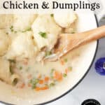 A pot of chicken and bisquick dumplings with peas and carrots, topped with fluffy dumplings. A wooden spoon rests in the creamy dish. Text on the image reads, A Bisquick Classic Chicken & Dumplings.