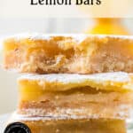 A close-up of three stacked lemon bars dusted with powdered sugar. The bars have a golden, crumbly crust and gooey lemon filling. Text reads Old-Fashioned Lemon Bars with theurbankitten.com at the bottom.